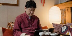 거실에서 태블릿을 보고 있는 시니어의 모습