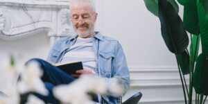 햇살이 잘 드는 거실에서 화분을 돌보는 시니어의 평화로운 모습