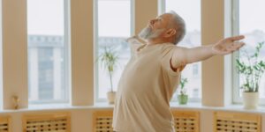 밝은 거실에서 가벼운 스트레칭을 하는 시니어의 모습