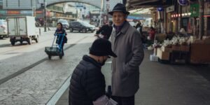기차역 플랫폼에서 휠체어를 이용하는 시니어를 돕는 역무원의 모습