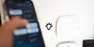 거실 벽면에 설치된 IoT 응급안전안심서비스 센서와 편안하게 휴식을 취하는 시니어의 모습