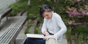 공원 벤치에서 접이식 방석을 사용하며 휴식을 취하는 시니어의 모습